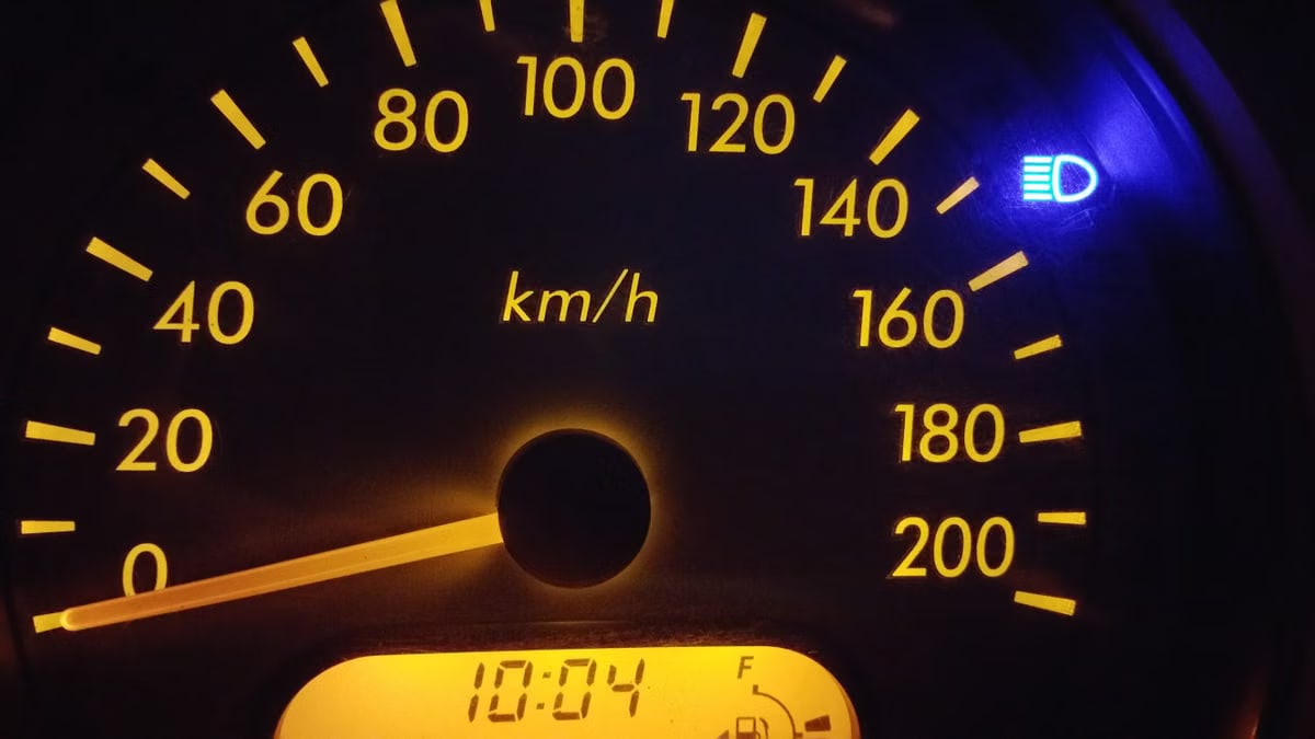 Close-up of an illuminated car speedometer display showing kilometers per hour.